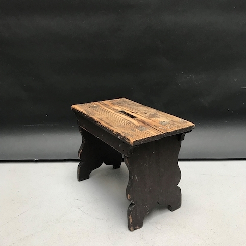 Picture of short primitive stool in scraped off dark brown wood